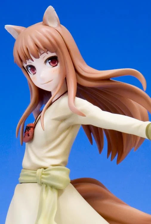 A 1/8 scale figure of Holo from Spice and Wolf, featuring a young girl with wolf ears and a white-tipped tail, dressed in a white outfit with a yellow belt, against a blue background.